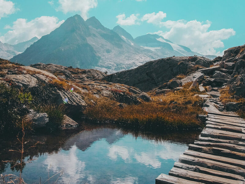 wood plank bridge leading to mountain landscape | representative of partial retirement